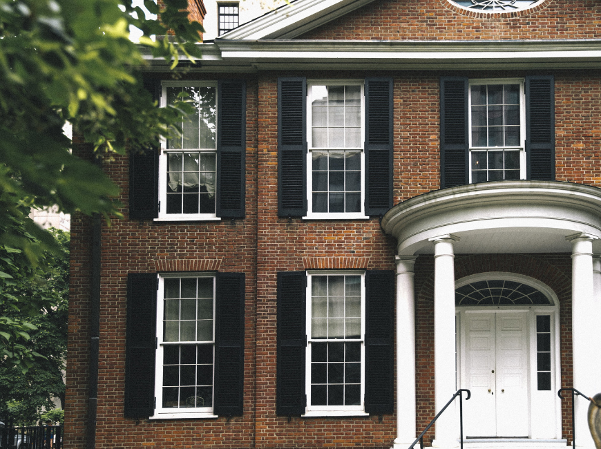 brick house with black shutters and white door